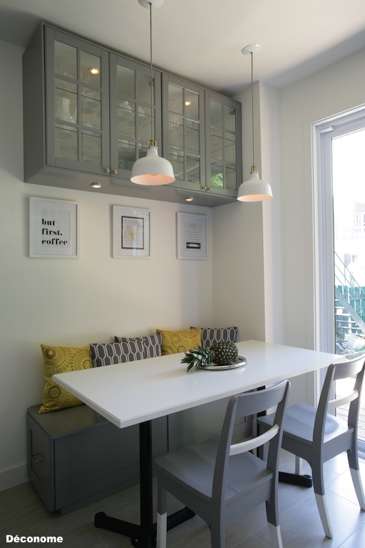 Coin banquette gris et blanc. Table pieds en fonte