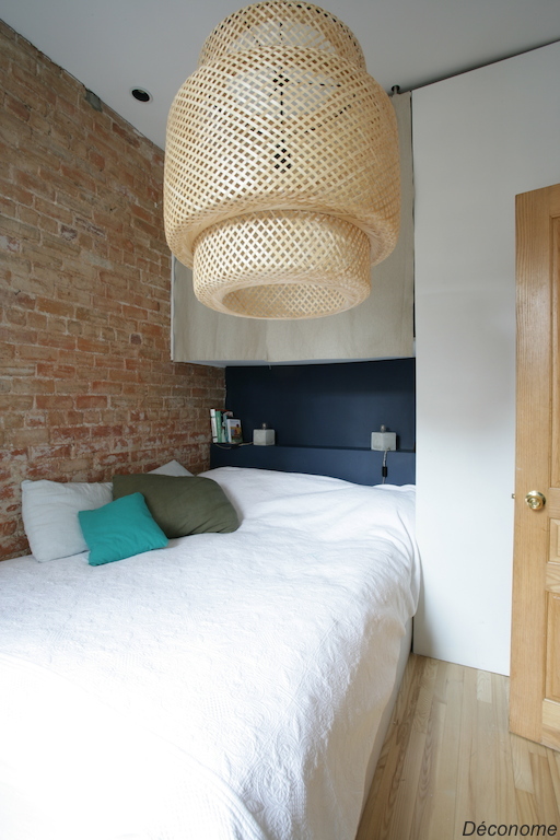 chambre avec mur de brique et mur bleu ambiance naturelle. Luminaire en rotin / ratan lampshade natural bedroom with a brickwall