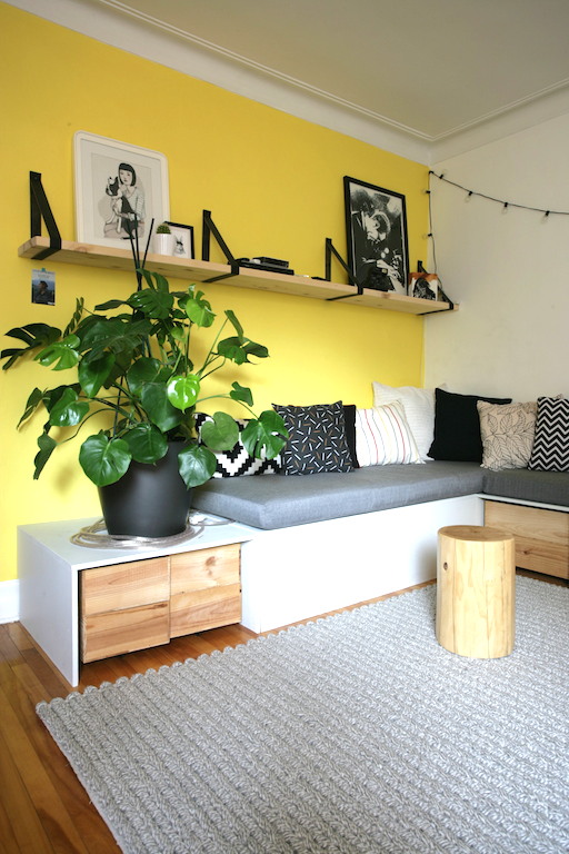 salon mur jaune canari, banquette faite sur mesur et étagères en ceintures / Living room with yellow wall, shelves made with belt and a handmade bench