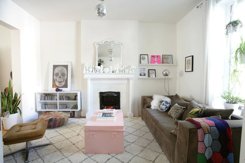 Grand salon avec tapis beni ouairai, cheminée et meubles vintage / loving room with morrocan rug and milk glass porcelain on the fireplace