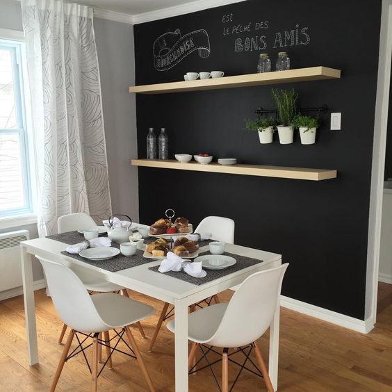 Mur tableau noir et étagères bois dans salle à diner