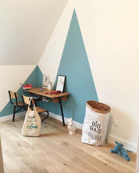 Bureau écolier triangles bleu peints au mur