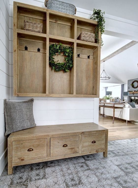 banc d'entrée et casier en bois dans une entrée de style farmhouse. Carreaux style ciment à motifs