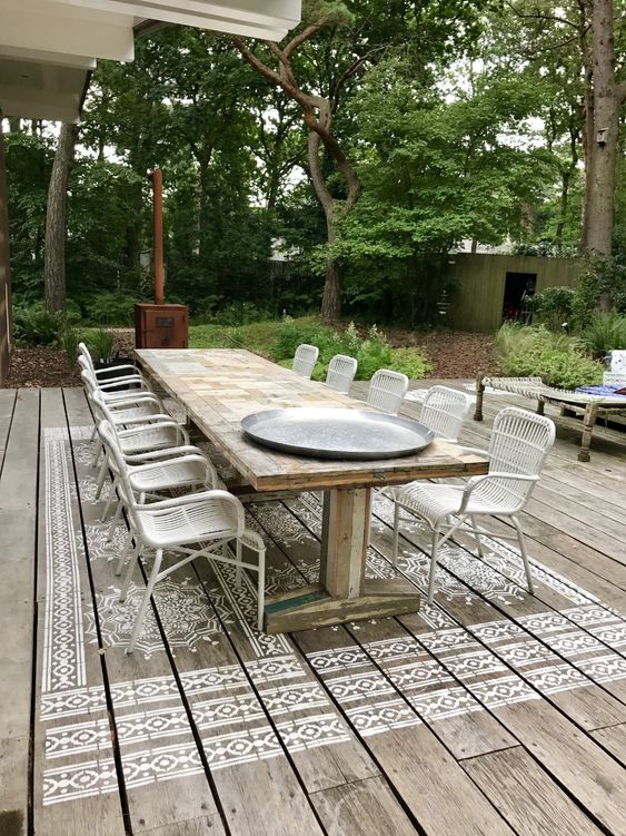 pochoir de mandala géant peint sur terrasse en bois. Faux tapis sous la table