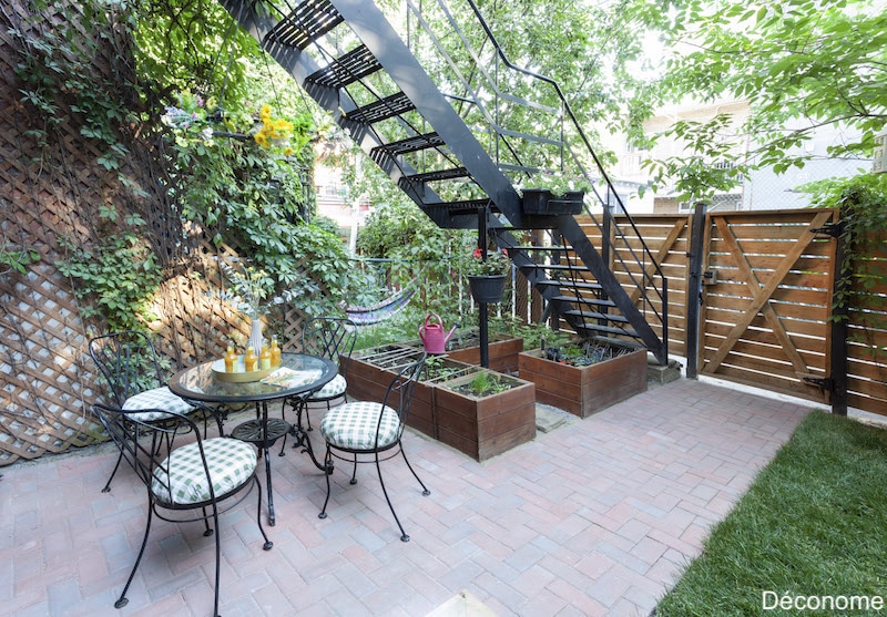 Petit jardin avec terrasse en pavés de béton rouge posés en chevron