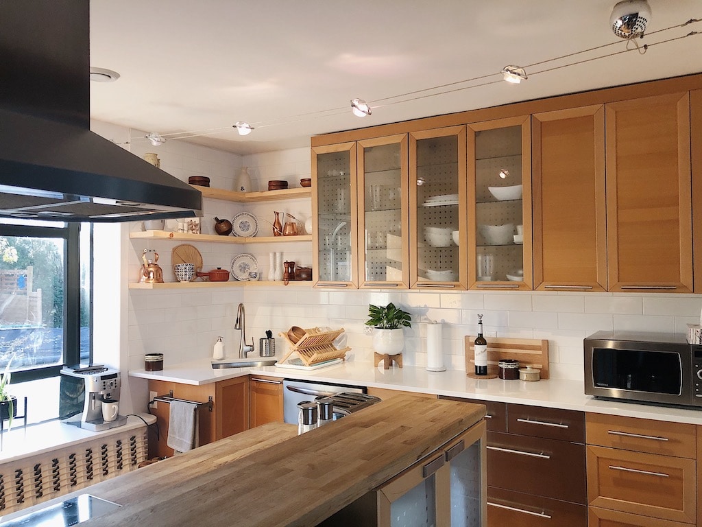 armoires de cuisine en bois modernisées avec comptoir de quartz et carreaux blancs