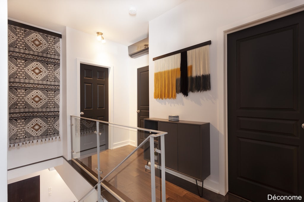 Décoration de couloir avec idées petit budget: tapis suspendu, portes peintes en noir et console IKEA modifiée