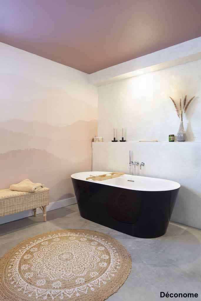 baignoire noire mur béton ciré et plafond rose salle de bain